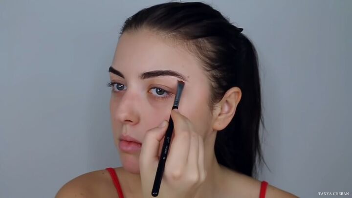 how to do effortlessly sexy red valentine s day makeup, Cleaning up eyebrows with concealer