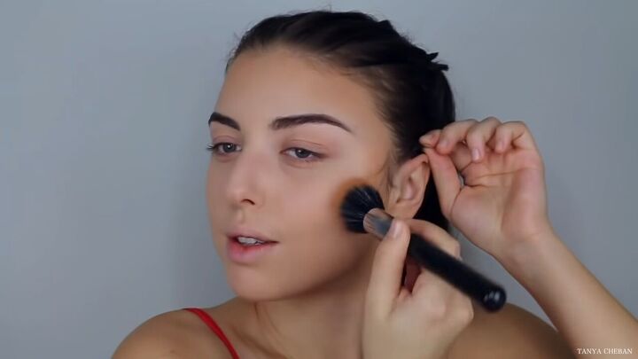 how to do effortlessly sexy red valentine s day makeup, Applying bronzer to the cheekbones