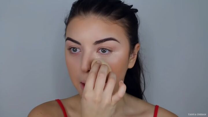 how to do effortlessly sexy red valentine s day makeup, Applying concealer under the eyes