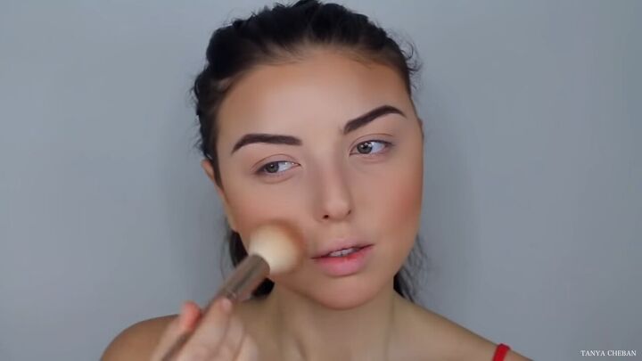 how to do effortlessly sexy red valentine s day makeup, Applying a rose gold blush to cheeks