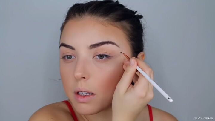 how to do effortlessly sexy red valentine s day makeup, Applying black eyeliner to elongate the eyes
