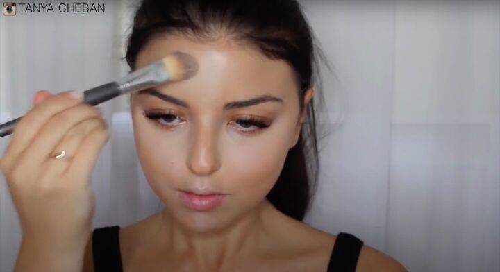 simple contouring highlighting baking routine for a natural glam, Applying highlight to the center of the forehead