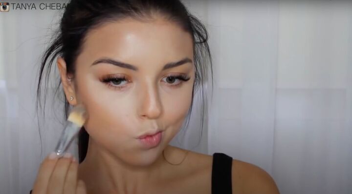 simple contouring highlighting baking routine for a natural glam, Applying bronzer under the cheekbones