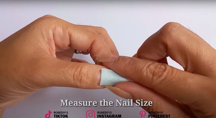 how to make diy fake nails out of a face mask baby powder, Measuring the mask pieces against the nail