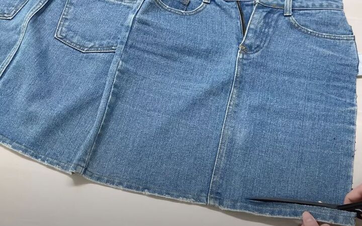 how to make a quick simple diy denim tote bag out of a jean skirt, Cutting off the bottom hem of the denim skirt