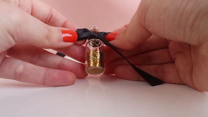 how to easily make diy jar necklaces filled with glitter salt more, Adding a black ribbon to the bottle