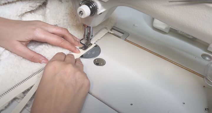 how to sew a sweater with a cute cropped hem half zipper, Sewing the twill tape to the zipper tape