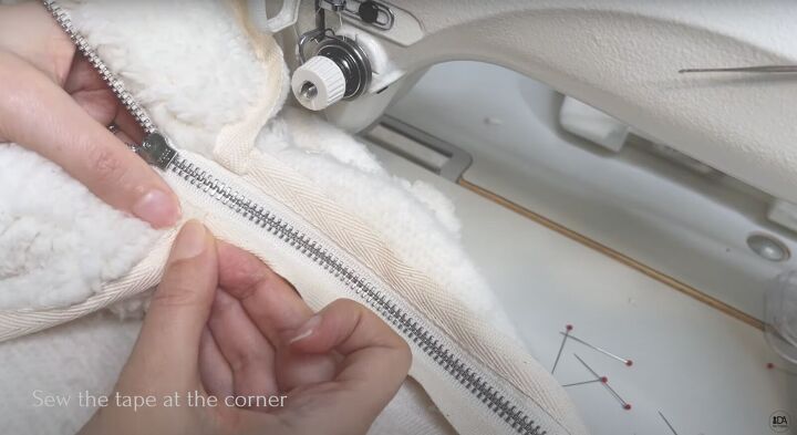 how to sew a sweater with a cute cropped hem half zipper, Sewing the tape to the corner