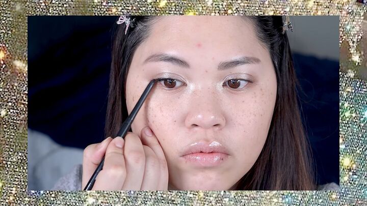 put a spin on 90s makeup with this fun 1990s inspired makeup tutorial, Applying gel liner to the upper waterline