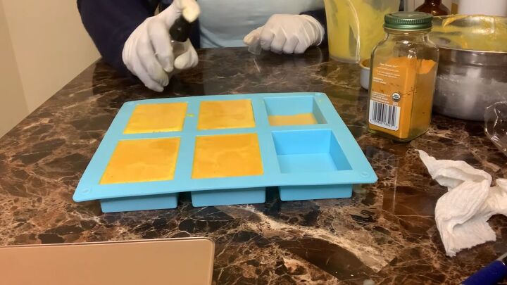 how to make a turmeric honey soap bar using a melt pour base, Spraying alcohol on top of the soap mold