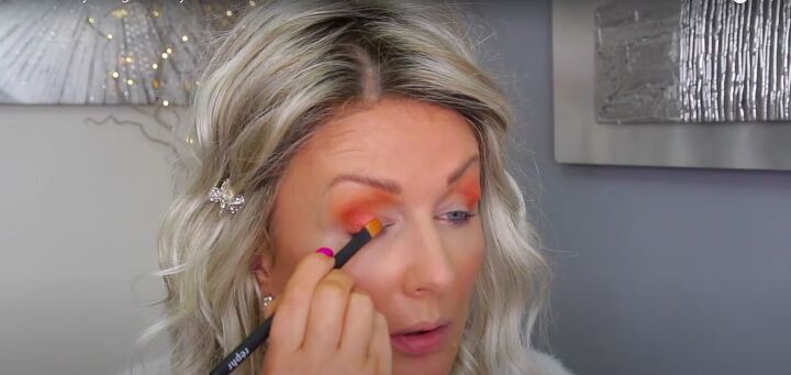 how to create a fiery orange eyeshadow look for summer or fall, Applying a pine toned eyeshadow to the base of the lid