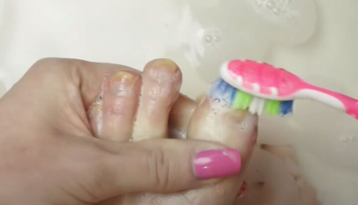 how to give yourself an amazing toenail makeover at home, Scrubbing toenails with a toothbrush