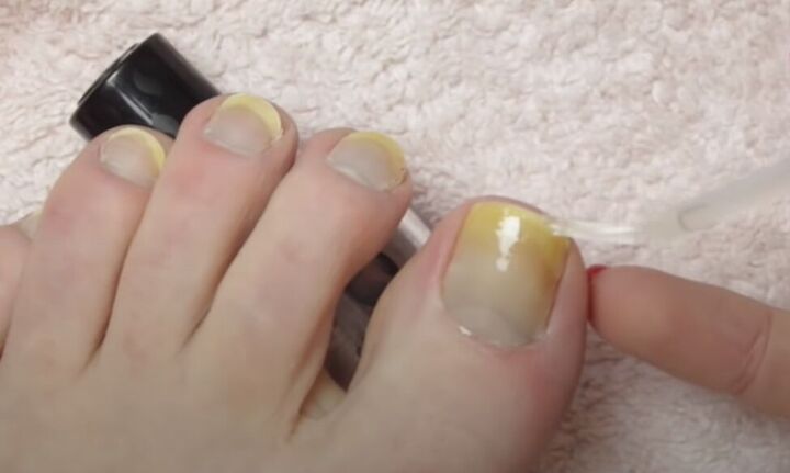 how to give yourself an amazing toenail makeover at home, Applying a base coat of nail polish to toenails