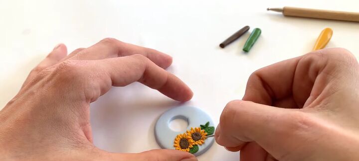 how to make adorable diy sunflower polymer clay earrings, Pressing yellow petals onto the sunflower