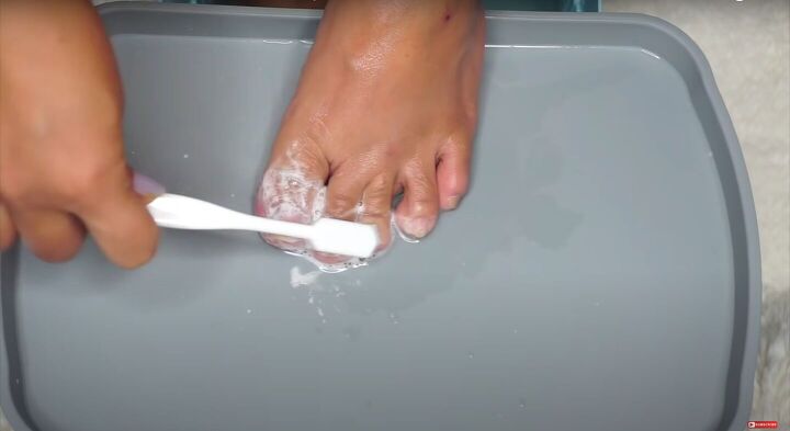 how to do an at home pedicure to get your feet ready for summer, Scrubbing toenails with a toothbrush