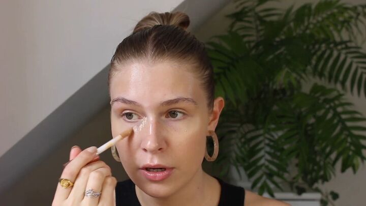 how to create a glowy bronze makeup look for spring summer, Applying concealer under the eyes