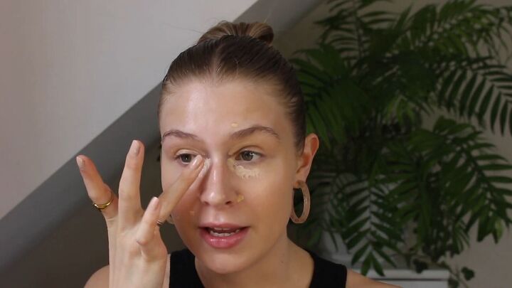 how to create a glowy bronze makeup look for spring summer, Blending under eye concealer with ring finger