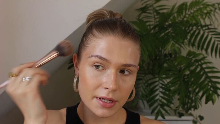 how to create a glowy bronze makeup look for spring summer, Applying bronzer to the temples