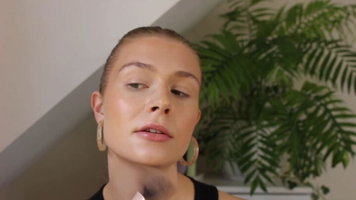 how to create a glowy bronze makeup look for spring summer, Applying bronzer around the face