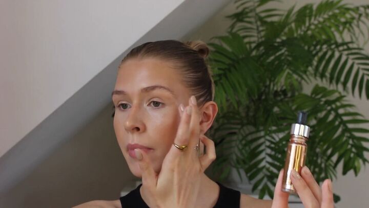 how to create a glowy bronze makeup look for spring summer, Blending highlighter with fingers