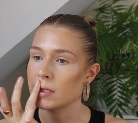 how to create a glowy bronze makeup look for spring summer, Applying highlighter to the cupid s bow