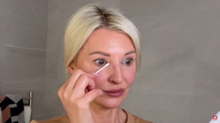 how to hide dark circles under eyes 8 key tips for women over 50, Cleaning up under eye makeup with a q tip