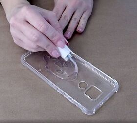 how to easily make a pretty pressed flower phone case for spring, Spreading the clear nail polish with the brush