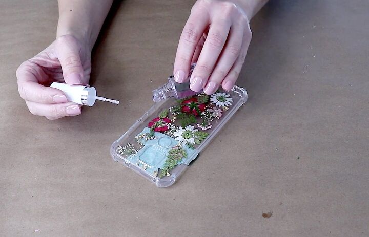 how to easily make a pretty pressed flower phone case for spring, Sealing the pressed flower design with clear nail polish