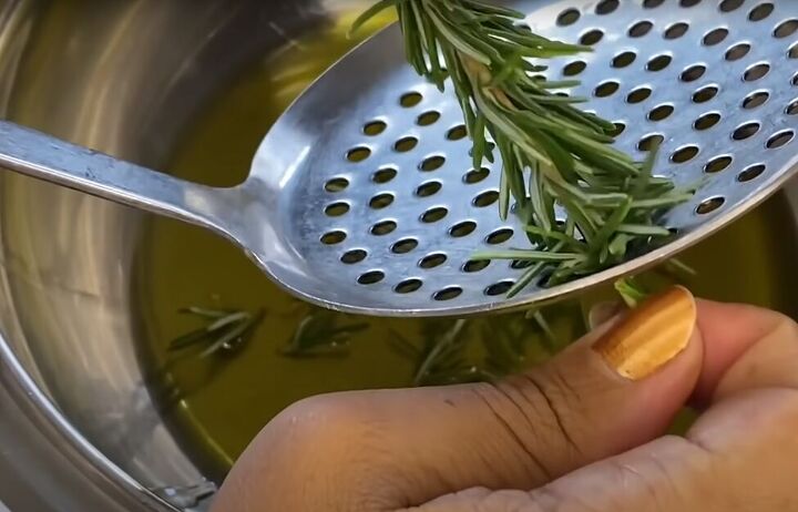 how to make use an effective diy rosemary oil for hair, Removing rosemary leaves using a strainer