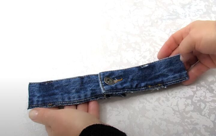 how to make a diy denim bracelet with a cute flower design, Cutting the waistband of old jeans