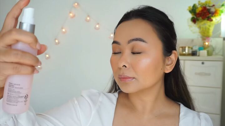 how to create a fresh dewy bright spring makeup look, Spraying hydrating mist over makeup