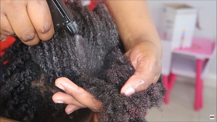 how to make detangling hair spritz with rosemary hibiscus tea, Spraying the hair spritz onto a section of hair