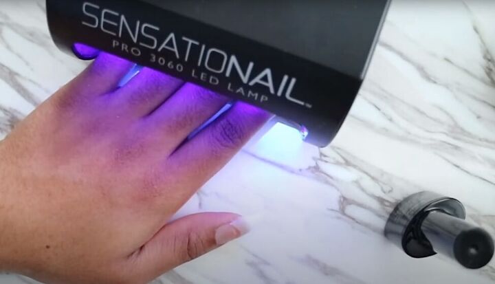 how to do diy polygel nails using nail tips from the dollar tree, Curing the base coat under a UV lamp