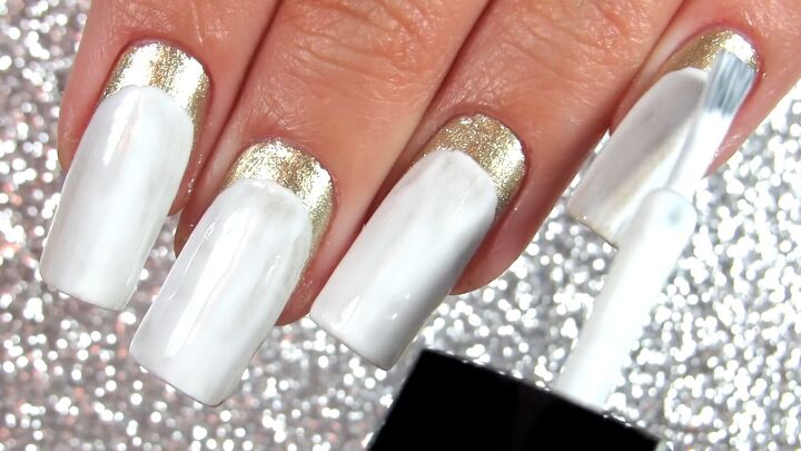 how to do elegant white gold nails with a half moon manicure, Applying white nail polish over the gold color