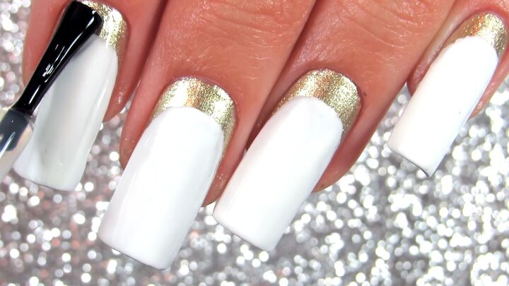 how to do elegant white gold nails with a half moon manicure, Applying a top coat over the white and gold nail design