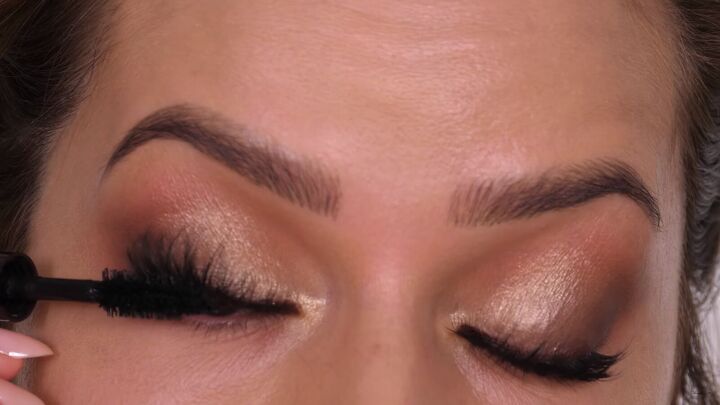 how to do a classic brown gold eyeshadow look that suits everyone, Applying mascara over the false lashes