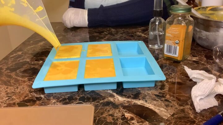 how to make a melt pour turmeric honey soap recipe, Pouring the turmeric and honey soap into the mold