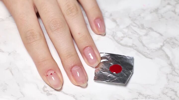 how to do glam dita von teese nails with a red half moon manicure, Making three dots along the half moon