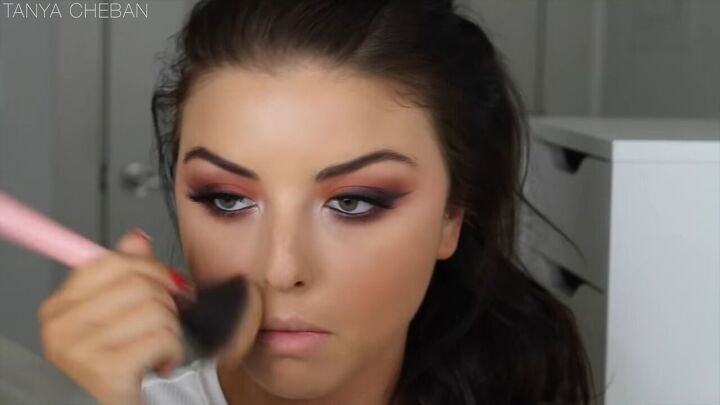 how to get ombre smokey eyes in just 20 minutes, Applying a setting powder to her face