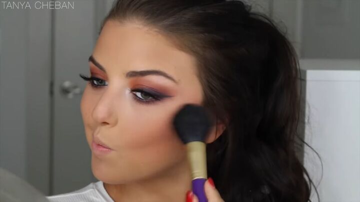 how to get ombre smokey eyes in just 20 minutes, Applying blush to her cheeks