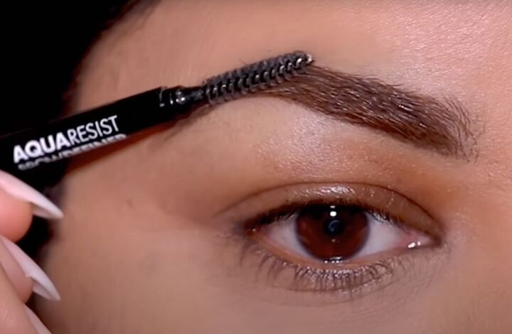 2 ways to apply eyeliner over glitter eye makeup for a seamless look, Using a spoolie brush to smooth brow hairs