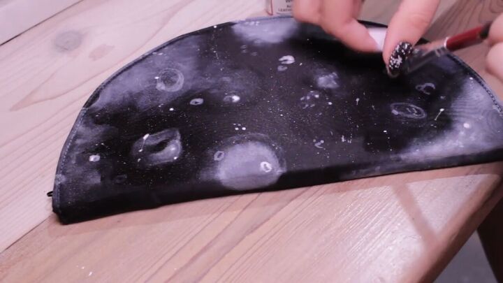 diy clutch painting how to make a glittering half moon design, Flicking white paint onto the clutch