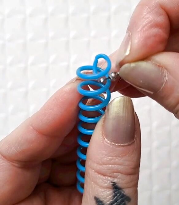 how to make diy spiral earrings other jewelry out of old notebooks, Looping the earring hook around the spiral