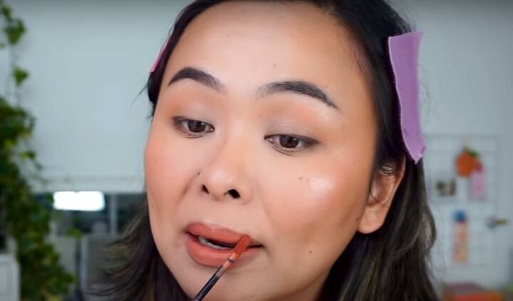 light fresh no foundation makeup look that s perfect for summer, Applying a brick toned lipstick