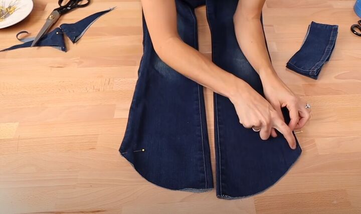 how to fray jeans in 7 different ways distress crop fray more, Cutting the length of the jeans on a curve