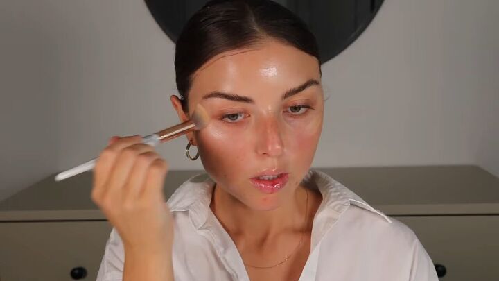 how to do clean girl makeup a natural no makeup makeup look, Blending the illuminator with a makeup brush