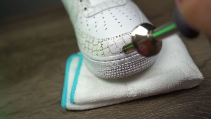 how to make textured diy croc skin sneakers with a wood burning tool, Using a wood burning tool to engrave croc print