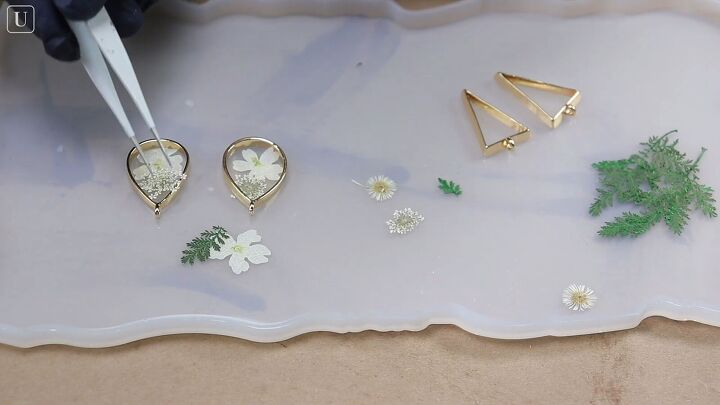 grab 2 plastic containers and make these gorgeous resin earrings, Using tweezers to arrange flowers