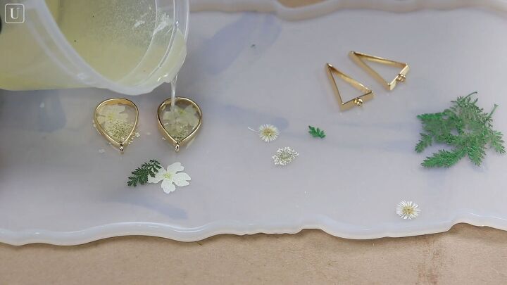 grab 2 plastic containers and make these gorgeous resin earrings, Gently pouring the resin into earring blanks