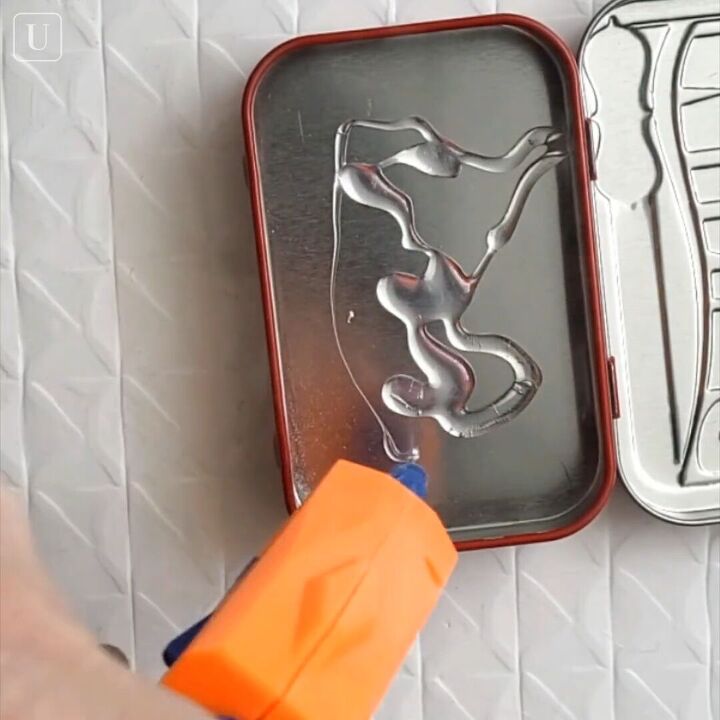 how to make a diy small jewelry box out of an old mint tin, Applying hot glue with a glue gun